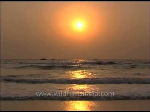 Sea waves reflecting orange sunset