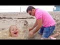 Stacy e papai brincam no mar na areia