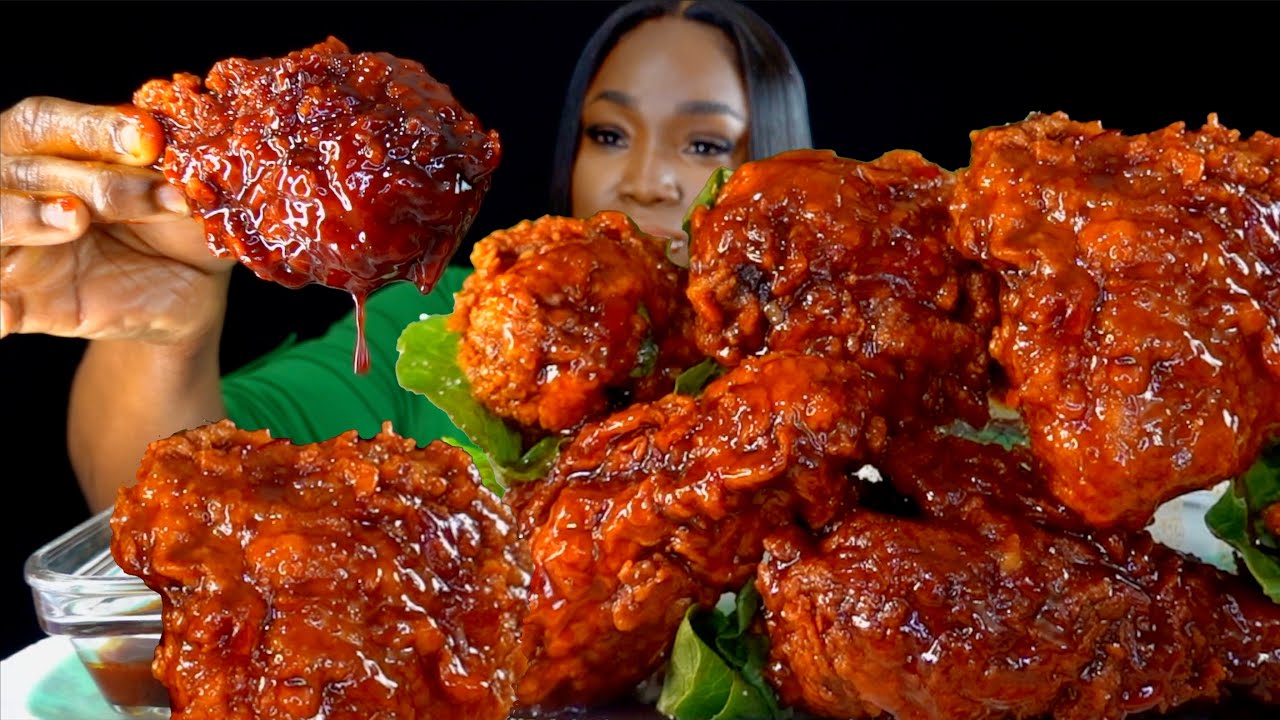 An ASMR mukbang creator eating Korean fried chicken with boiled eggs in front of a binaural microphone for an eating sounds video