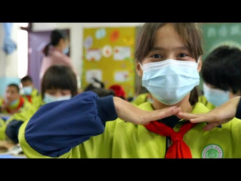 Alunos em Xinjiang, na China, dançam slides durante o intervalo da manhã