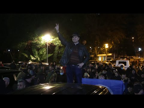 Me dy gishta lart, dhëndri i Sali Berishës qëndron sipër makinës së Lulzim Bashës