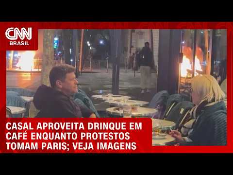 Vídeo: Casal aproveita drinque em café enquanto protestos tomam Paris | CNN BRASIL