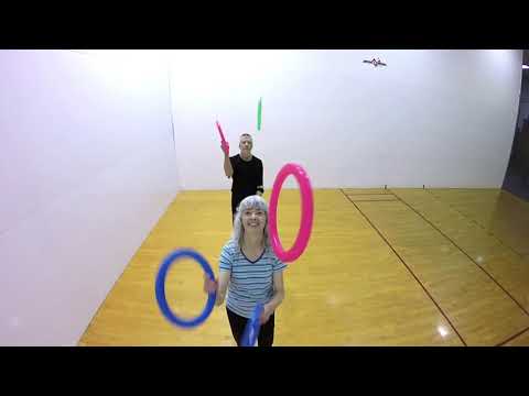 Woman Performs Pass Juggling Trick With Man While Looking Away From Him - 1217888-7