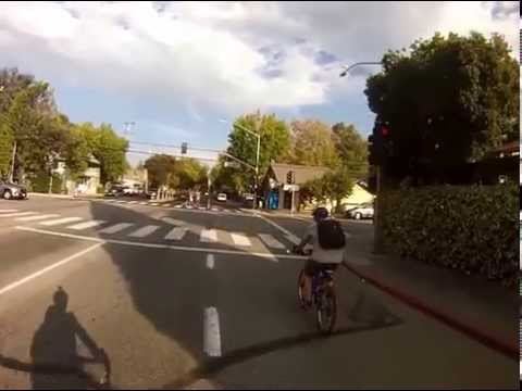 Light running doorzone dope says "USE THE BIKE LANE" on an empty street