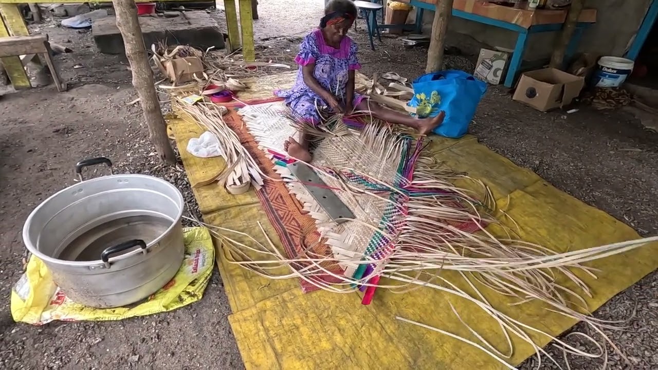 Weaving a mat from grass leaves, Nguna Island, Vanuatu