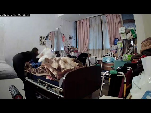 Caregiver shields ailing woman with pillow during earthquake