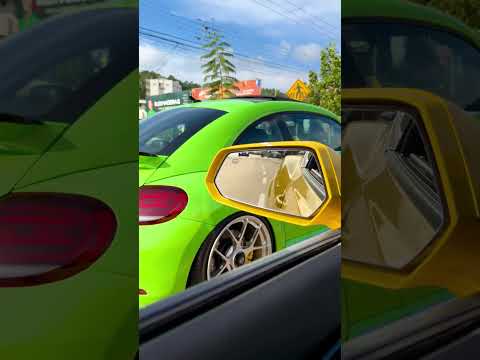 Fusca verde e Camaro amarelo no centro da cidade