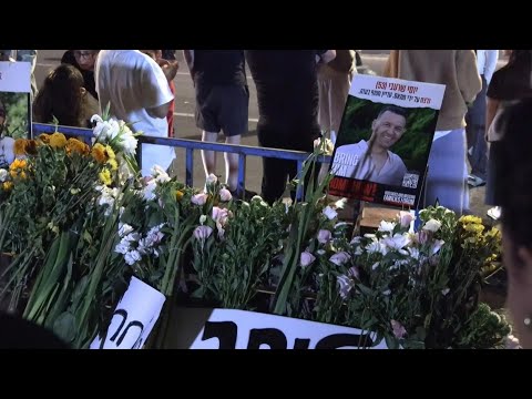 Israelis lay flowers in front of forensic center after arrival of deceased Gaza hostages | AFP