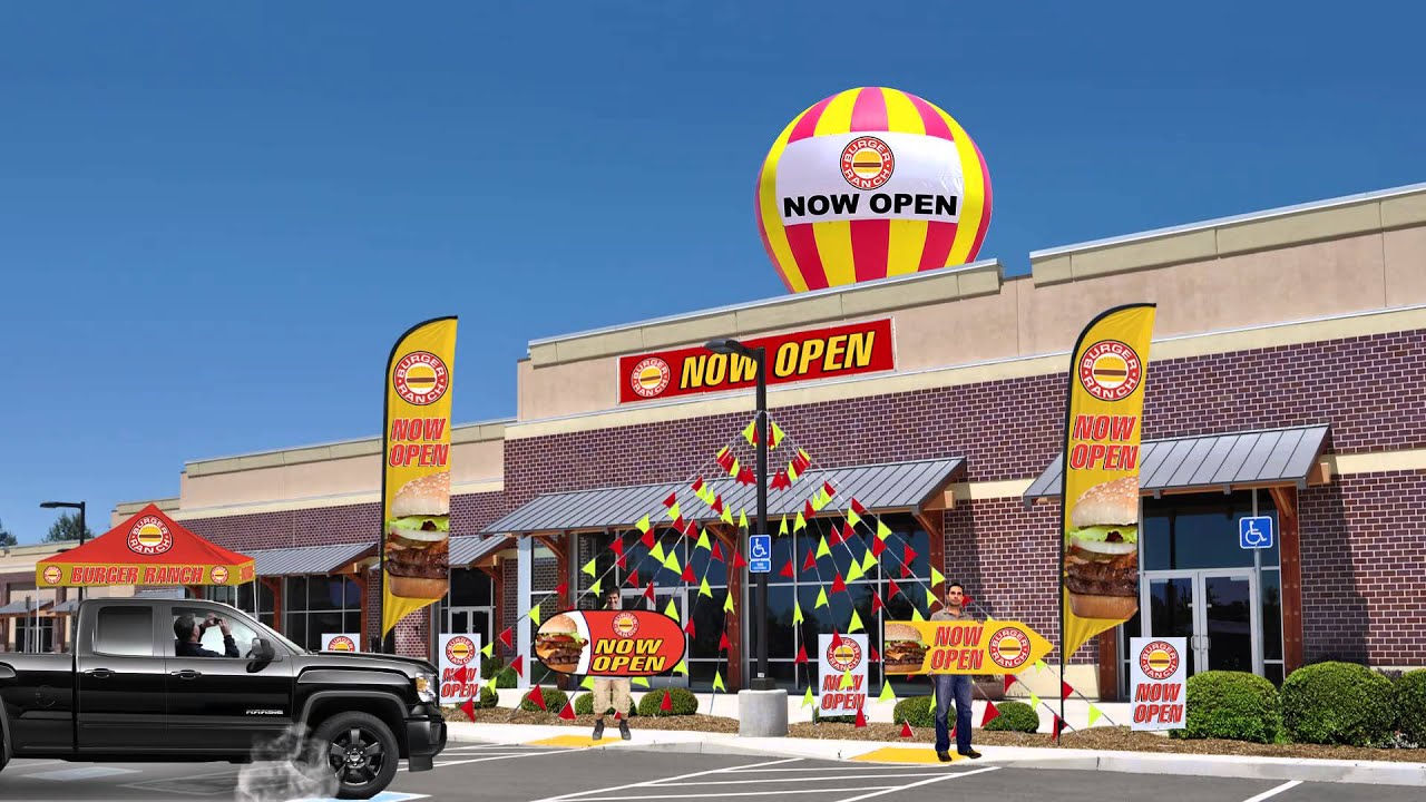 storefront with advertising inflatables, pennant string flags, adversail flags and spinner signs
