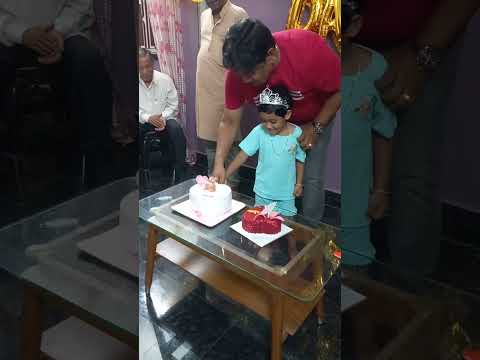 sweet girl is cutting her birthday cake