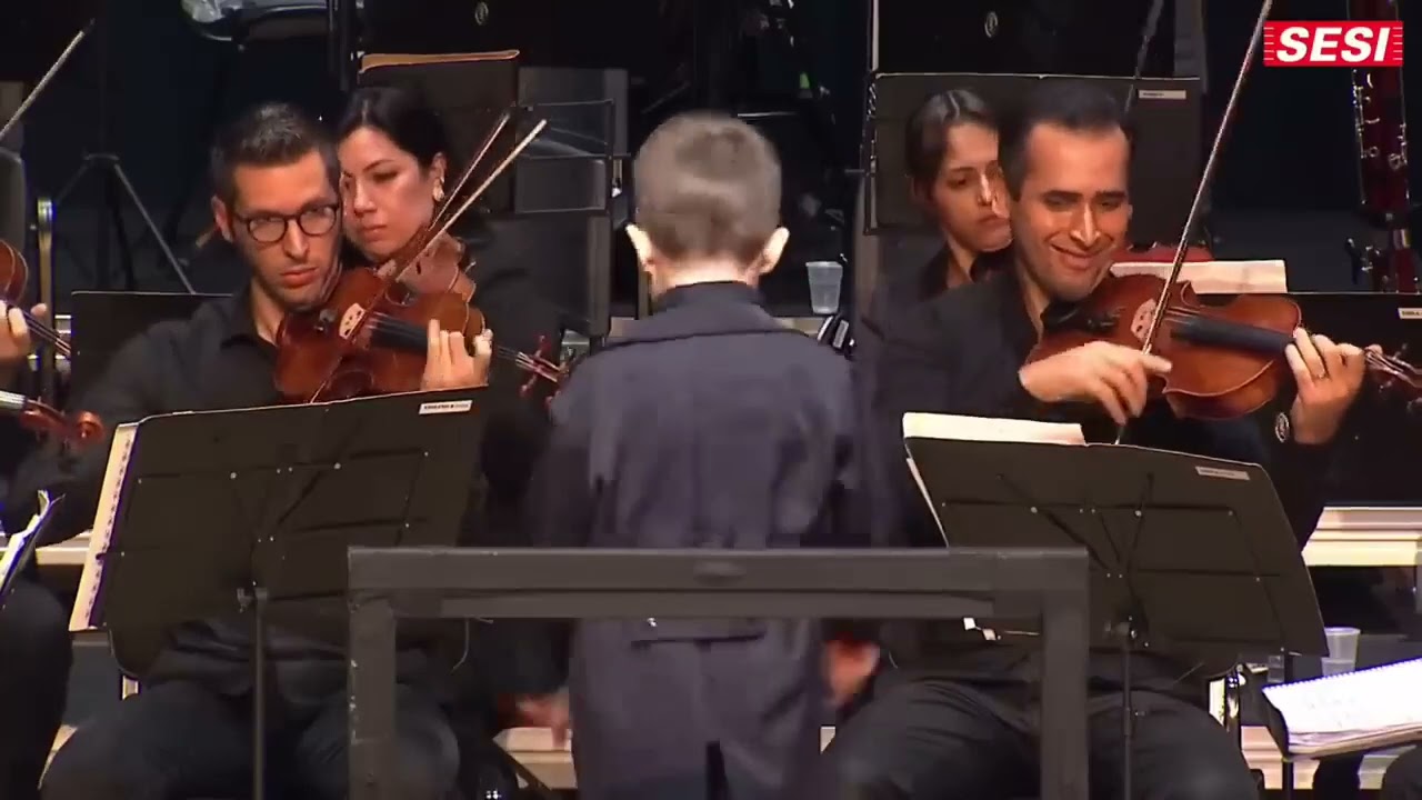 Criança se apresenta com maestro João Carlos Martins em SP. Retirado do canal @CentroCulturalFiesp.