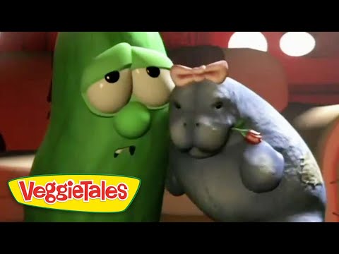 Larry the Cucumber and a gray hippo from VeggieTales share a friendly hug, with the VeggieTales logo in the bottom-left corner.
