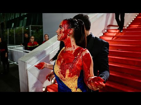 Woman clad in Ukrainian colours pours fake blood on herself at Cannes Film Festival