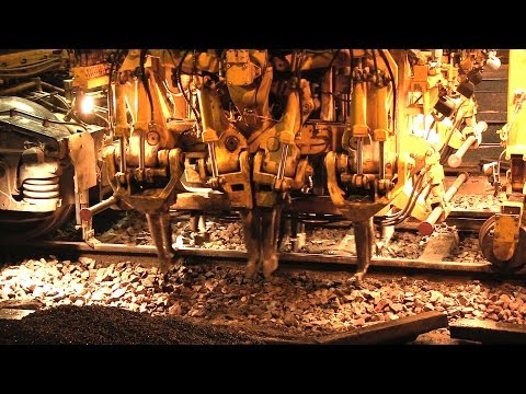 Gleisstopfmaschine Plasser & Theurer Unimat 09-32/4S und Schotterpflug am Bahnübergang