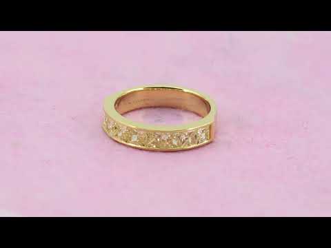A fancy yellow channel set diamond band in 18k yellow gold