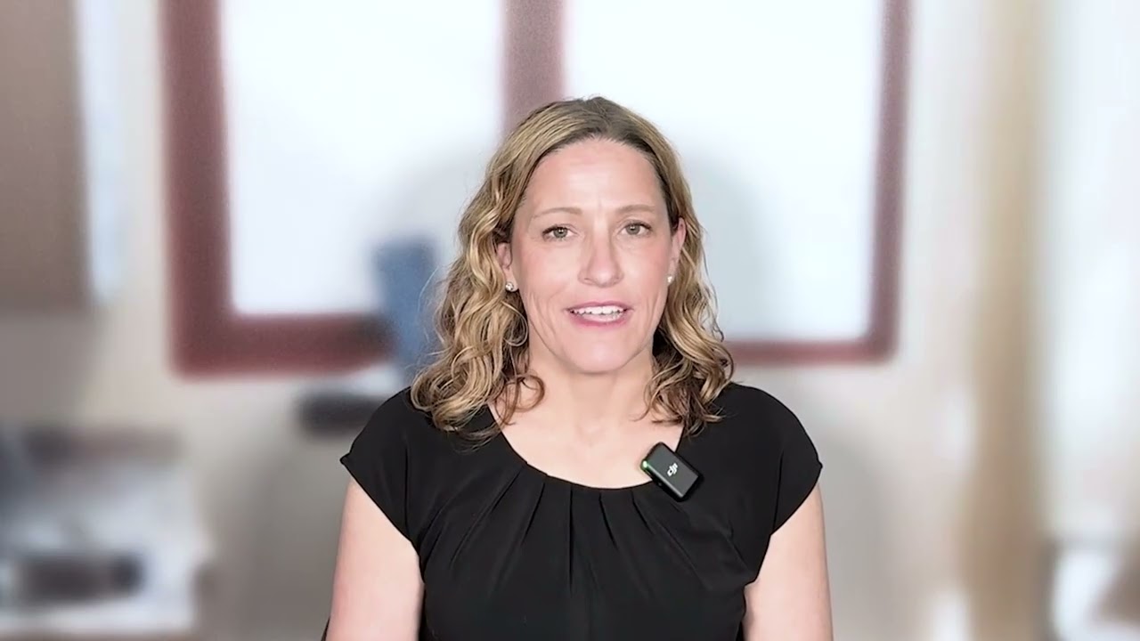 Dr. Kathleen Legarza, MD, Radiation Oncologist, sitting in front of a blurred window