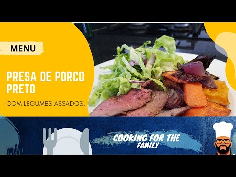 Presa de porco preto com legumes assados no forno