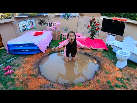 Casa de papelão com piscina de lama no pátio