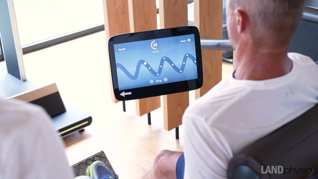 Kunde im medizinischen Training mit Blick auf Trainingskurve auf Bildschirm von EGYM Gerät