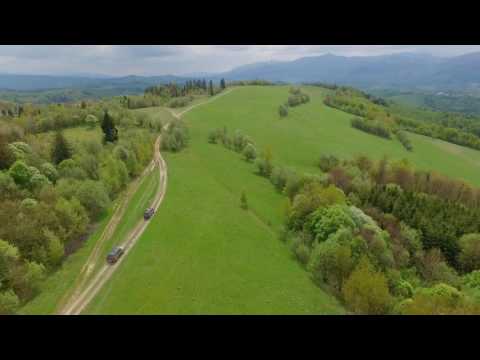 Suv Convoy Traveling Through the Mountains of the Carpathians. the Camera Flies Over the Trees and
