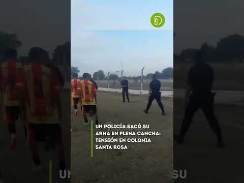 Un efectivo policial desenfundó su arma ante hinchas en la cancha.