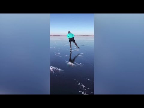 滑冰者滑過荷蘭的湖泊 (Skaters slide across a lake in the Netherlands)