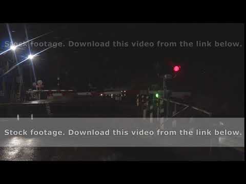 The traffic lights at the railway crossing flashes red at night