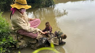 smart and cute DuDu and BiBi babies monkey with mother on the bridge visit to water