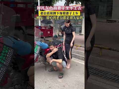 The motorcycle is too high for the wife to get on, so the husband immediately crouches down to