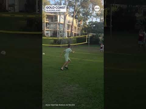 Boys play ball with kangaroo at Australia resort