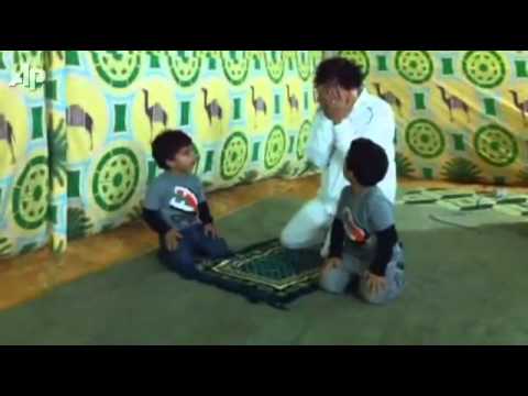 معمر القذافي يضحك في الصلاة ويلاعب احفاده