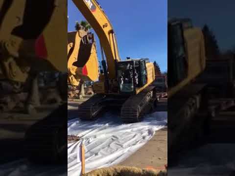 Unloading a cat 336 excavator over the back of a transport trailer