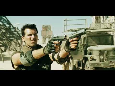 Trailer still: convoy under a brutal sun—music shifts from guitars to industrial pulse as story descends underground