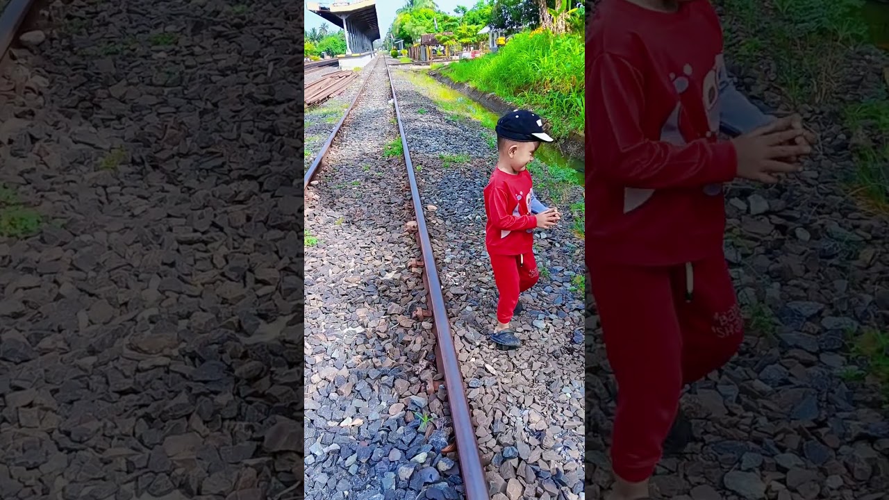 A small engineer is checking the train tracks and ditches.