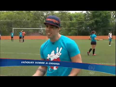 Fernando Scherer e vocalista da banda He Saike disputam hóquei sobre a grama
