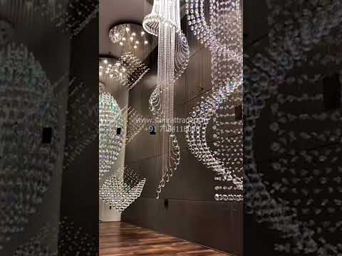 Luxury long height crystal chandelier installed in a premium home staircase and banquet hall, showcasing elegant vertical lighting design