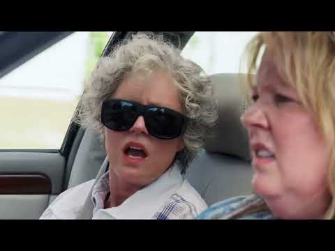 Tammy official trailer frame — Melissa McCarthy’s Tammy glares through a greasy fast-food window, paper bag hat and all