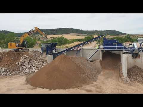 cat 323E alimentando planta de tratamiento de RCD's reciclaje de la construcción