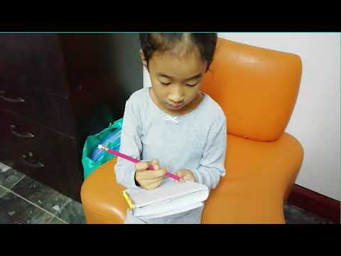 Keziah teaching the cat how to read.