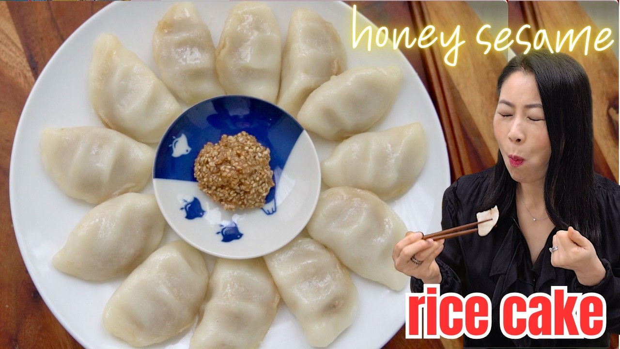 An open songpyeon rice cake split in half showing the honey sesame seed filling oozing out from inside the chewy white rice cake shell