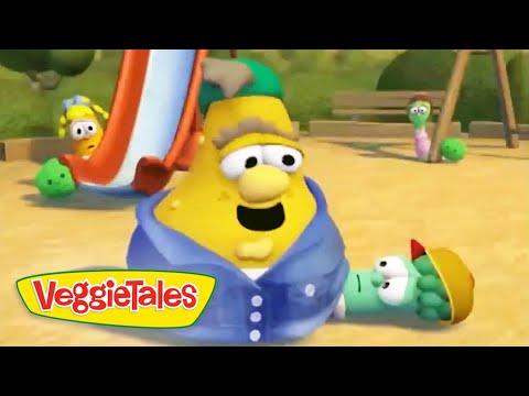 Yellow VeggieTales character wearing a blue hoodie sits on a sandy playground with a slide in the background and small green friends nearby, VeggieTales logo visible on the bottom left.