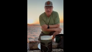 Alabama Outdoorsman Woodsman having Bushcraft Coffee on the Beach  at Fort  Morgan Alabama