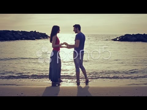 two lovers chase (run after) and kissing in the sea - beach - love - sunset. Stock Footage