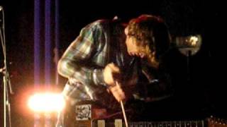 Thurston Moore playing guitar with a drumstick