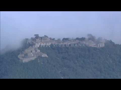 NHK VIDEO BANK - Aerial: A medieval castle shrouded by stunning morning mist -