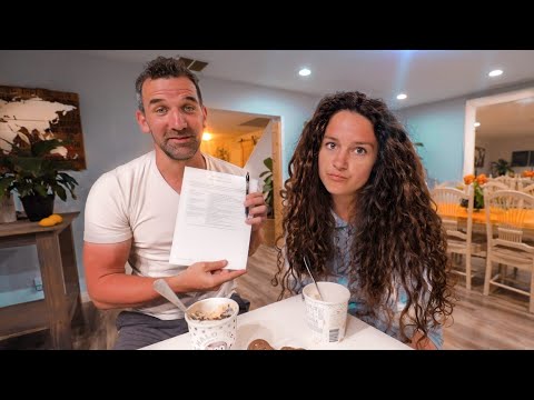 Man and woman at a cafe table with ice cream; the man holds a document and pen toward the camera.