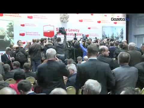 Leszek Miller otoczony przez fotoreporterów