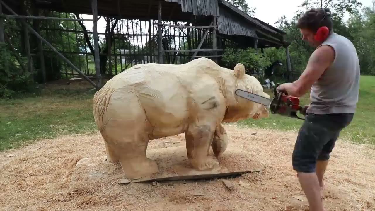 wooden sculpture of a bear using chainsaw by vlad