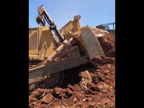 CAT D-8 pushing large rock