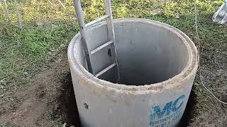 Hand digging a well for water in the UK with concrete drainage rings. Off grid water.